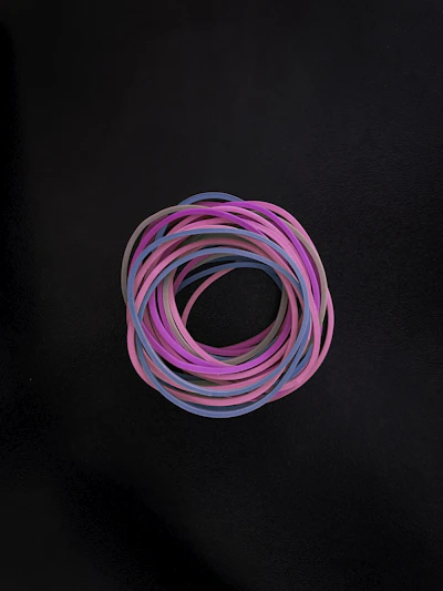 Stack of colorful O-rings in different sizes displayed on a wooden surface.