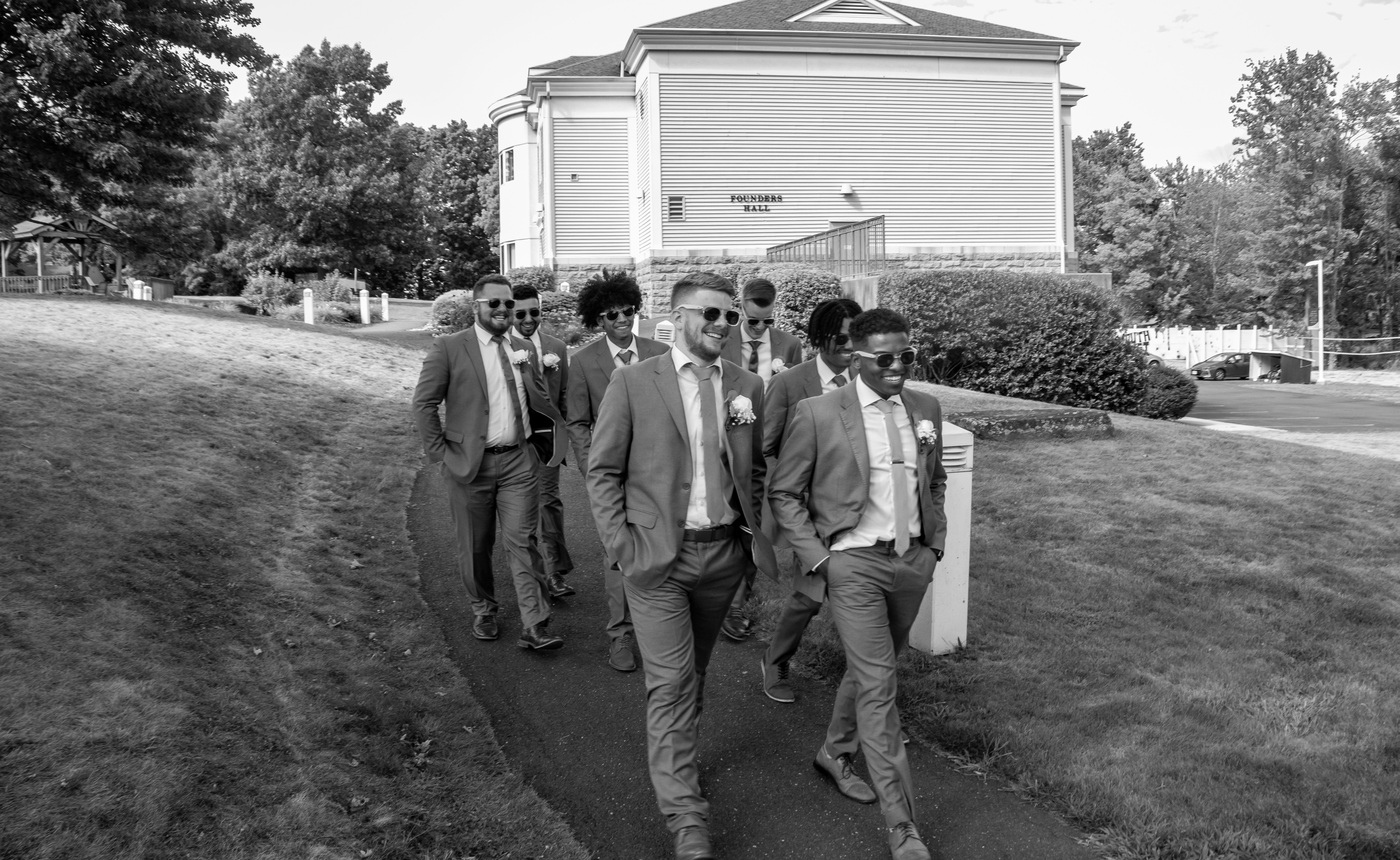 a group of men walking on a path in front of a house