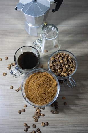 Vintage coffee maker on a rustic wooden table with coffee beans scattered around.