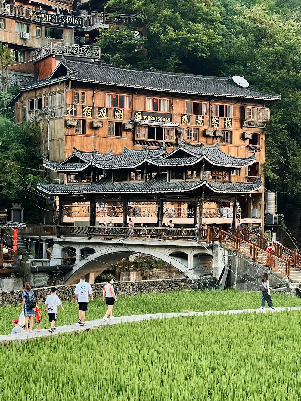 a group of people walking on a path in front of a building