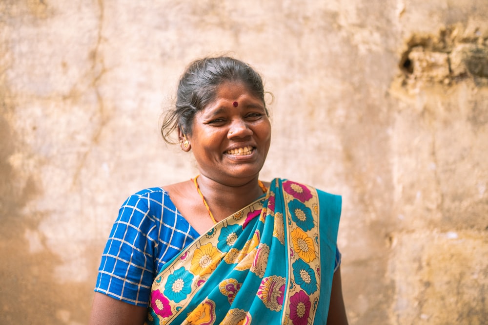 a person smiling in front of a wall