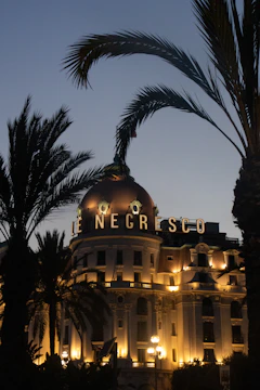 Exclusive balcony overlooking the Monaco Grand Prix track at dusk, bathed in burgundy and gold hues.