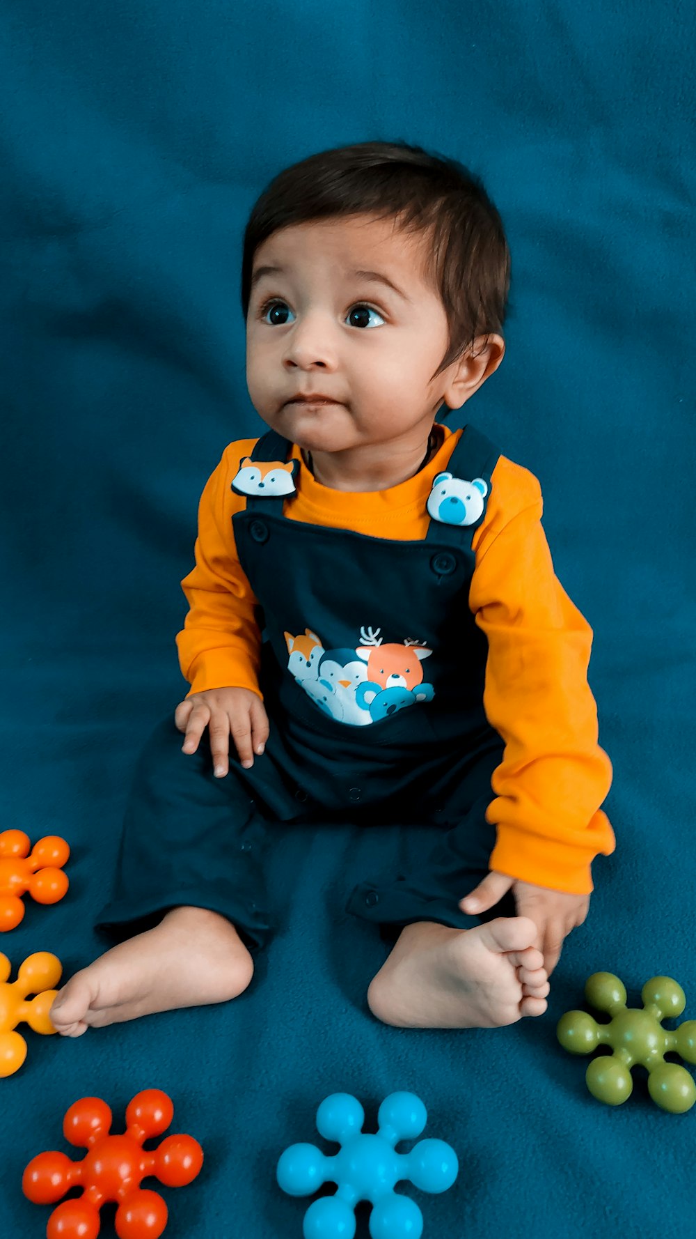 a baby sitting on a blue surface