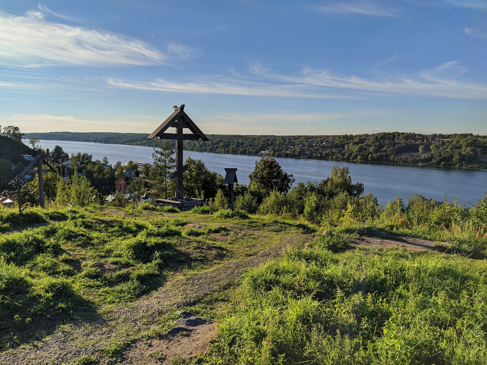 a cross on a hill by a body of water