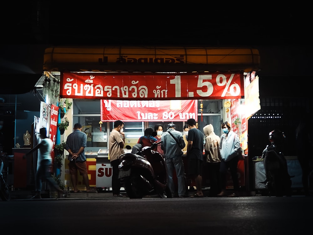 a group of people standing outside a restaurant