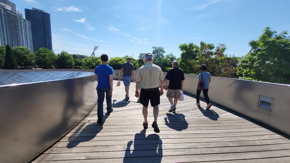 a group of people walking on a wooden bridge