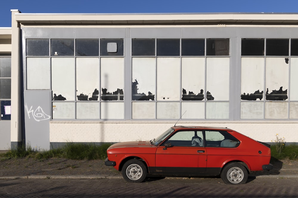 a red car parked in front of a building