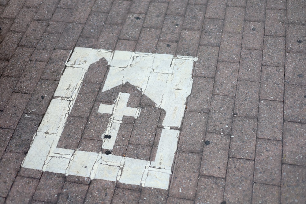 a brick walkway with a white sign