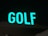 A brightly lit sign displaying the word 'GOLF' in large, green letters. The background is dark, suggesting the photo was taken at night.