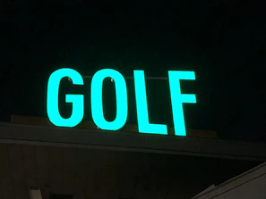 Wide-angle shot of the inflatable enclosure lit up at night with players teeing off.