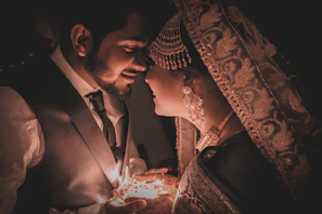 A couple smiling during a marriage compatibility session, with celestial motifs softly illuminating the room.