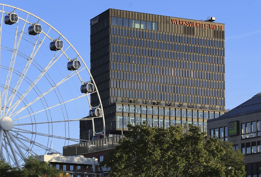 a large building with a ferris wheel in the background