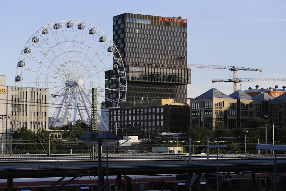 a large ferris wheel next to a train track