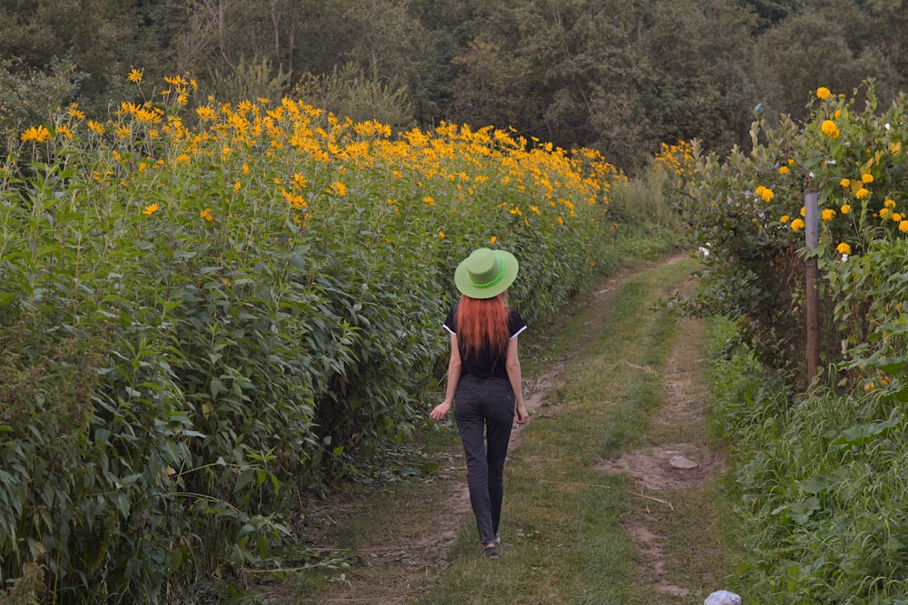 a man walking on a dirt path in a garden