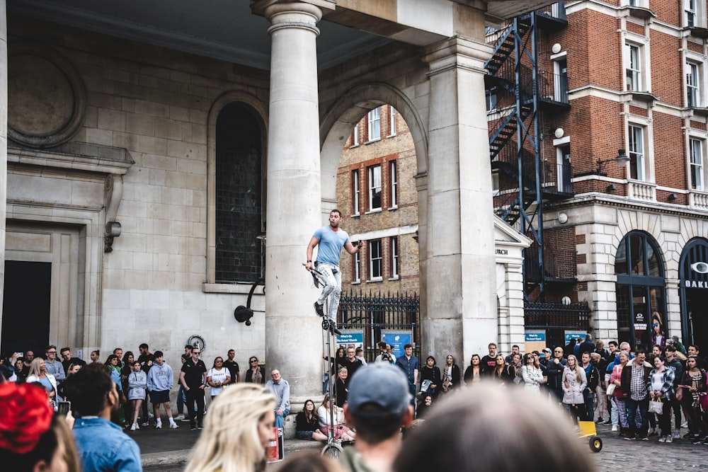 a person on a skateboard jumping off a pillar in front of a crowd of people