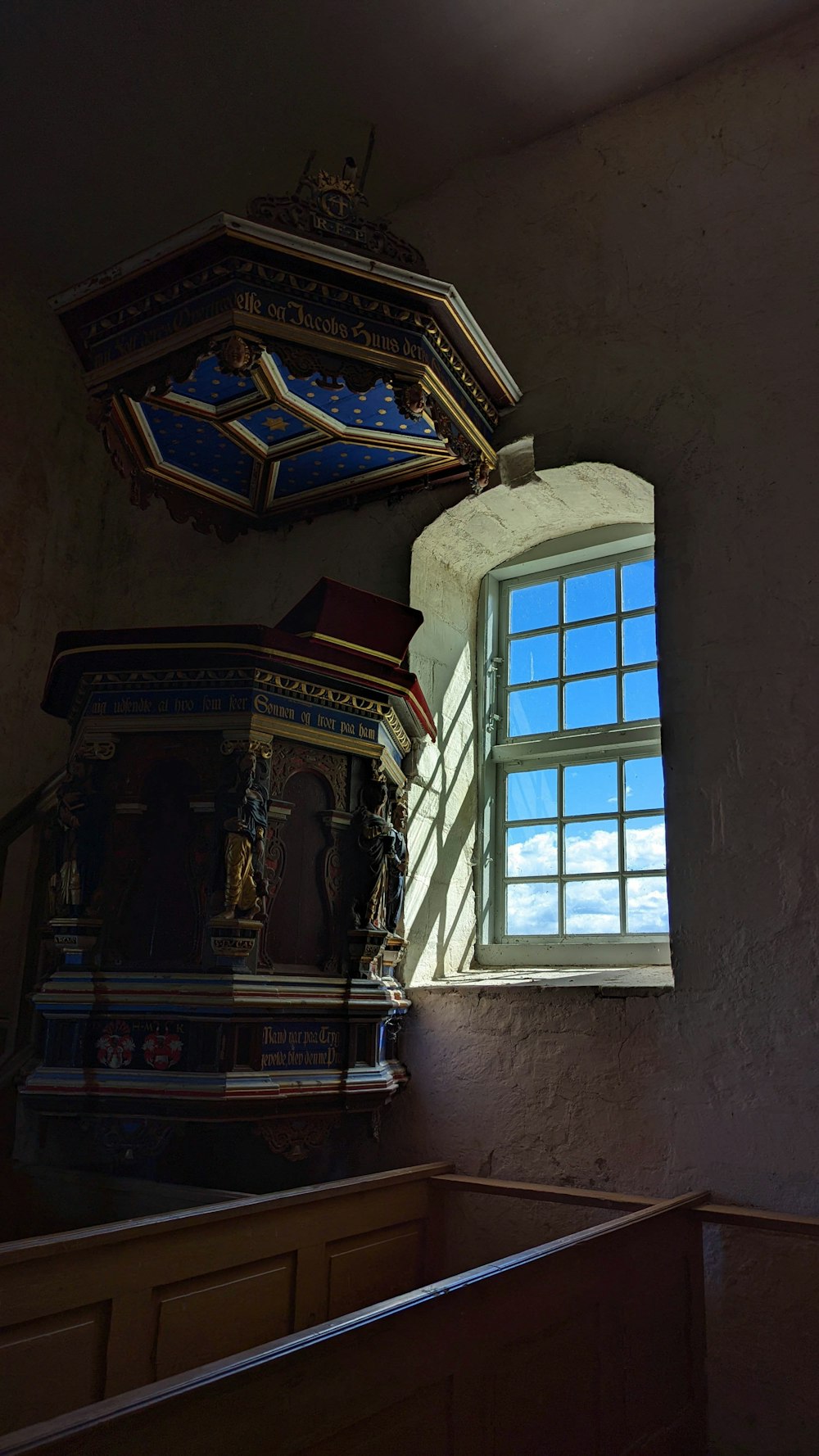 a room with a window and a shelf with statues on it