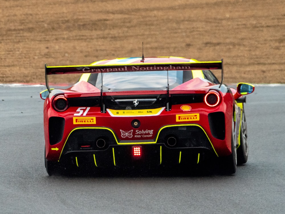 Un coche de carreras rojo y amarillo en una pista