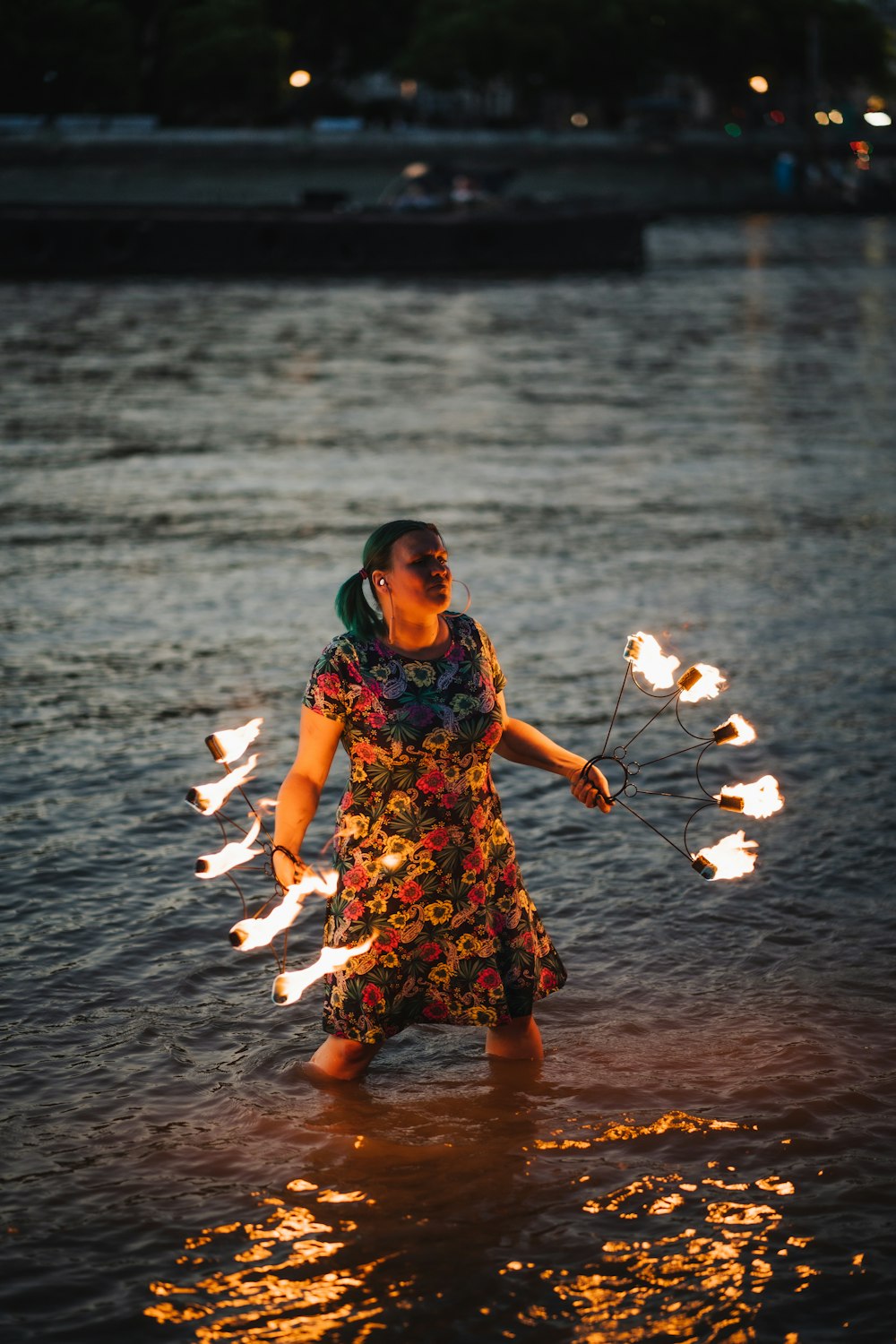 a person holding a stick and standing in water with a lot of fish