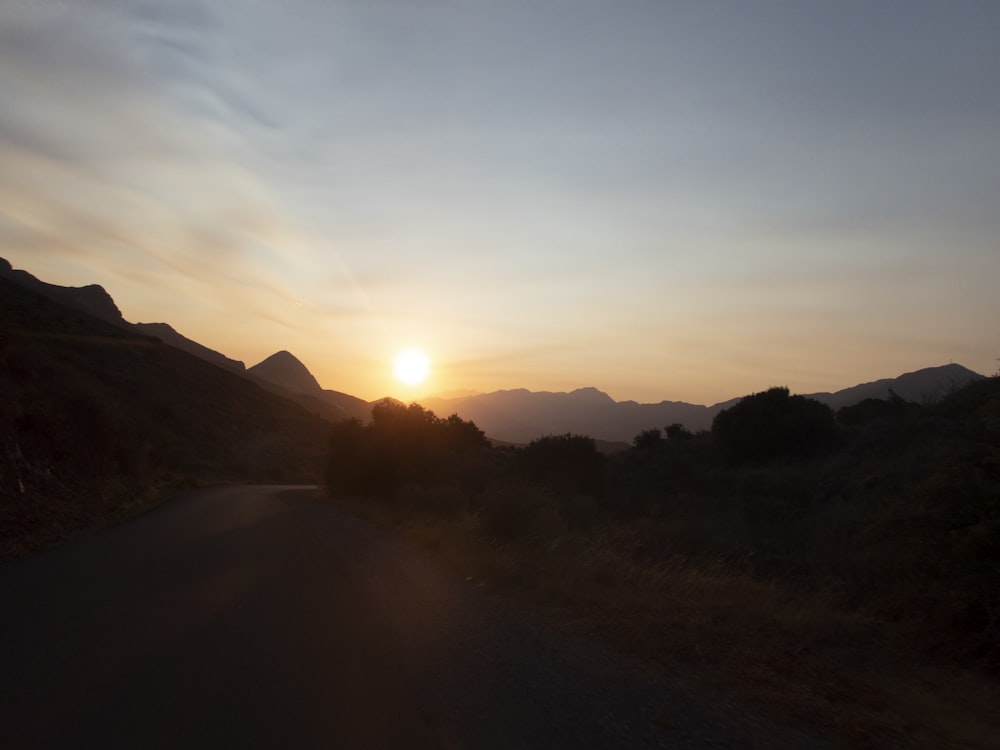 a road with trees and mountains in the background