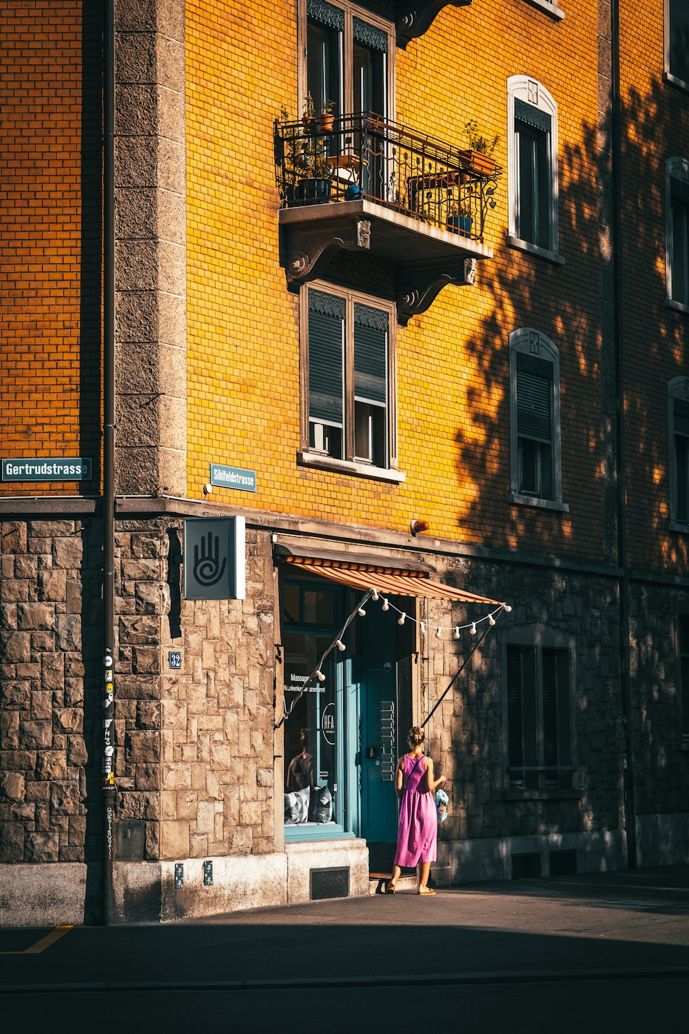 a person walking down a street in front of a brick building