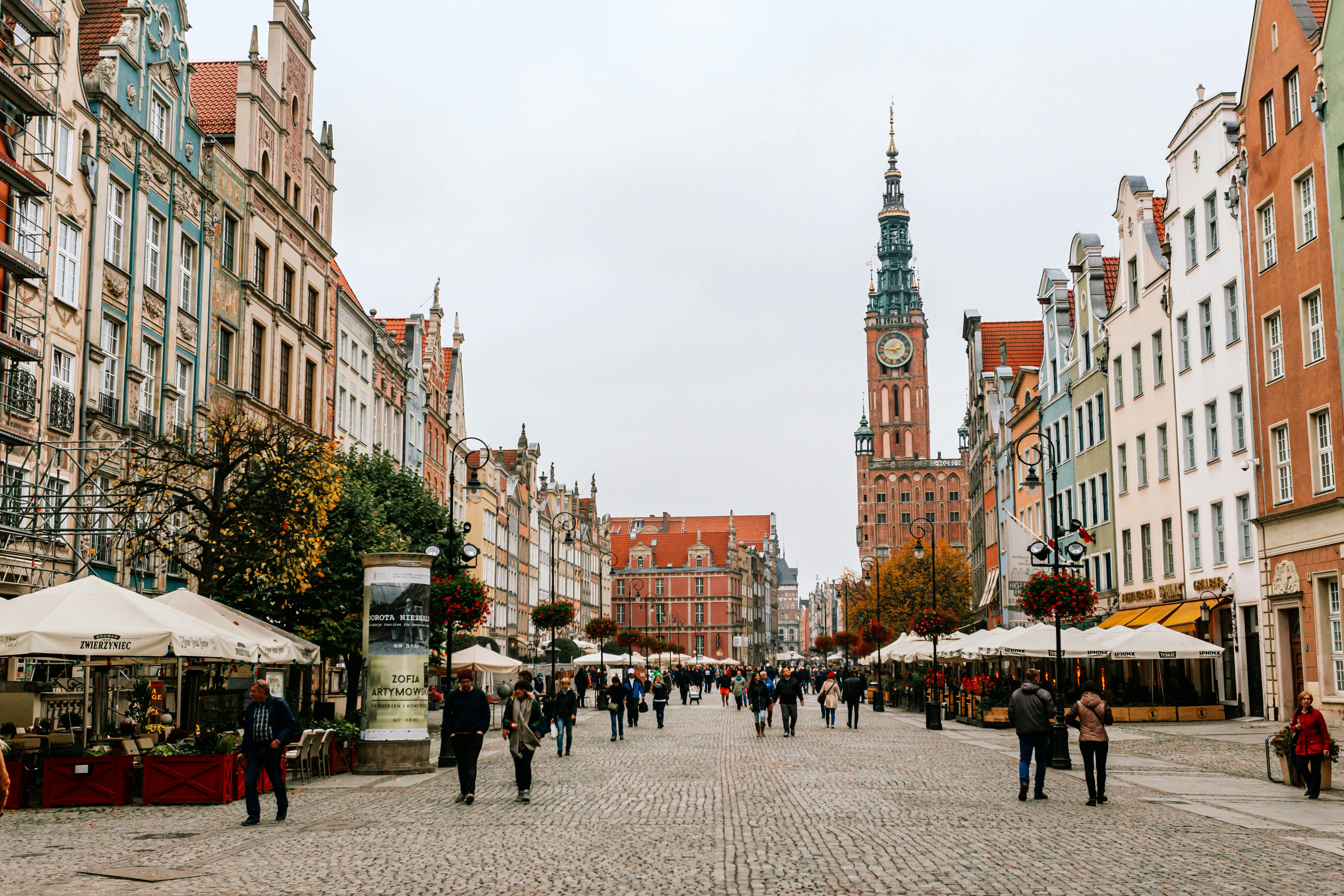 a group of people walking in a city, Gdansk at autumn time