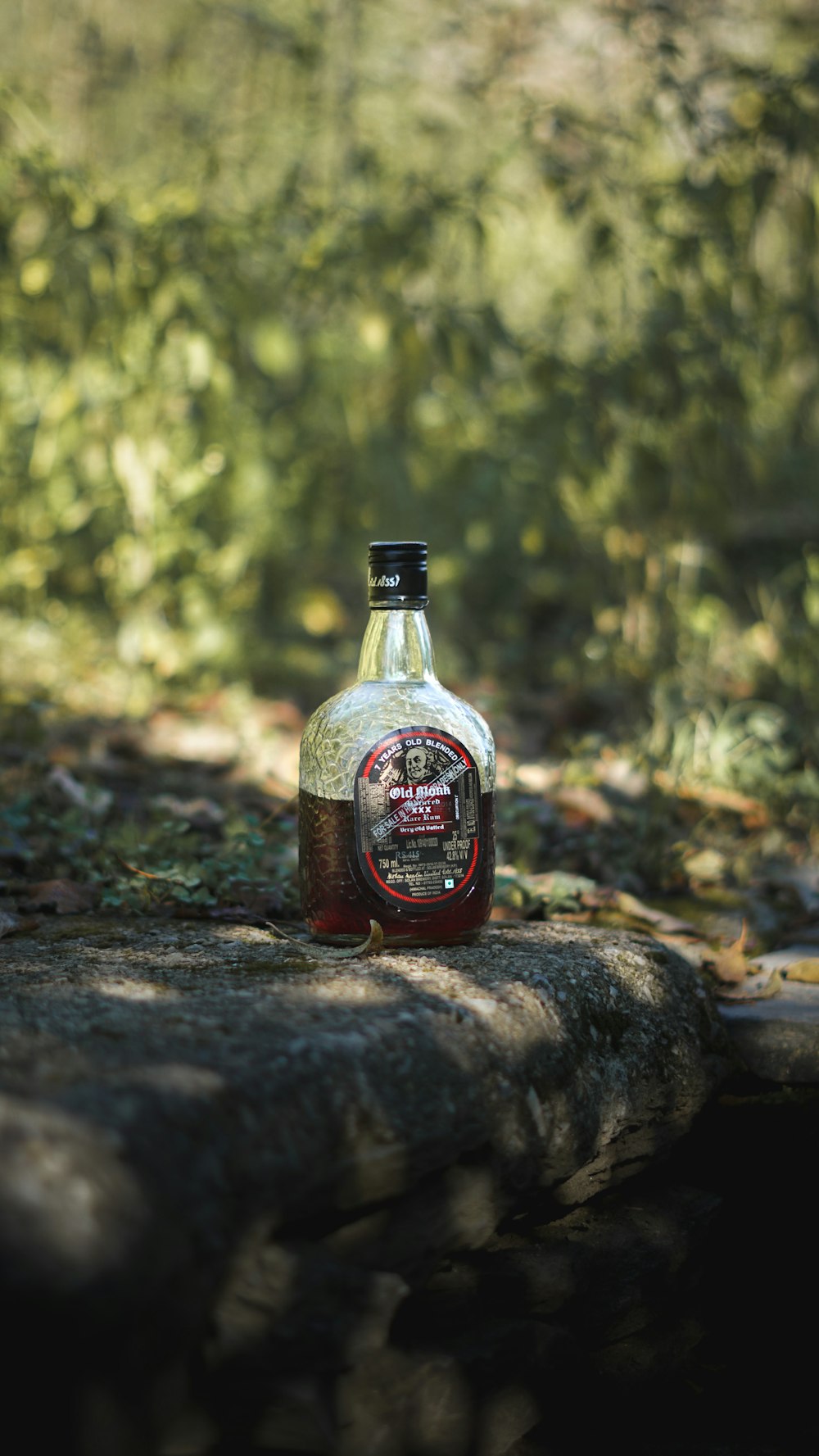 a bottle of alcohol on a rock