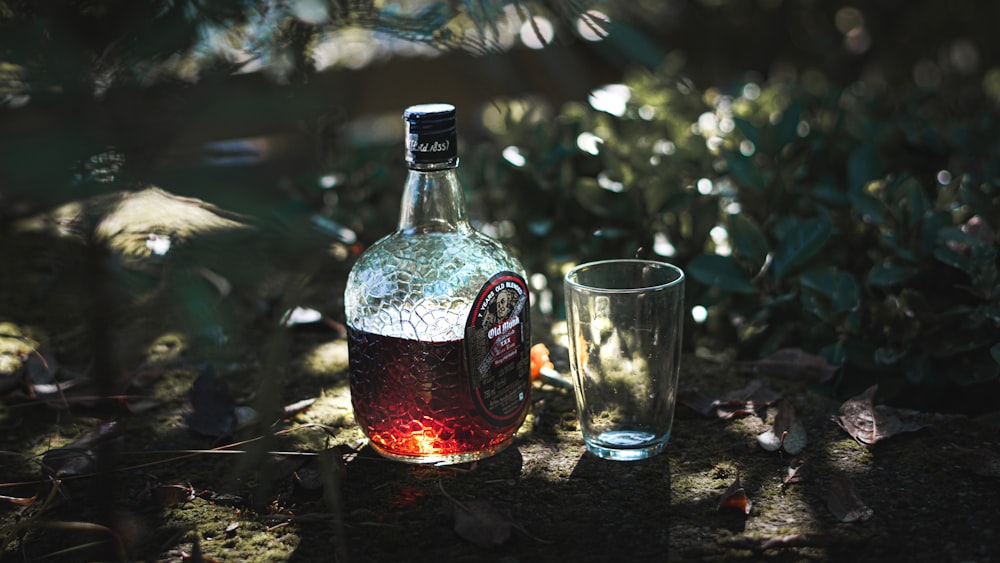 a bottle of alcohol and a glass of water on a table