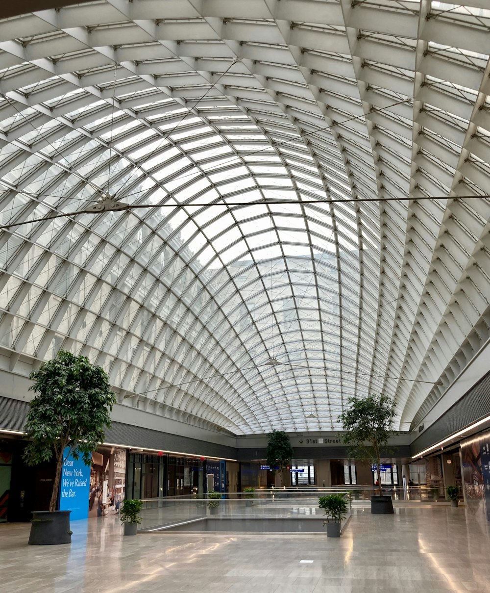 a large indoor mall with many trees with London King's Cross railway station in the background