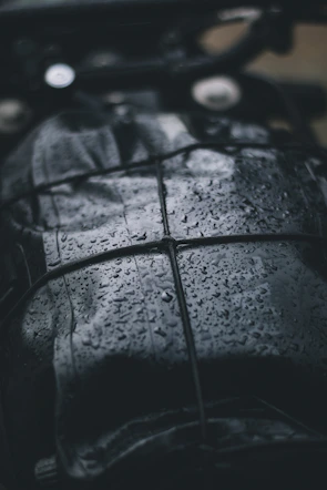Close-up of waterproof seams on a full-body rain suit glistening with raindrops.