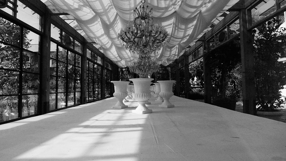a large room with a large white curtain and a large white vase with flowers in it