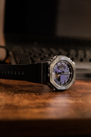 Close-up of a sleek nxz analog watch resting on a wooden table.