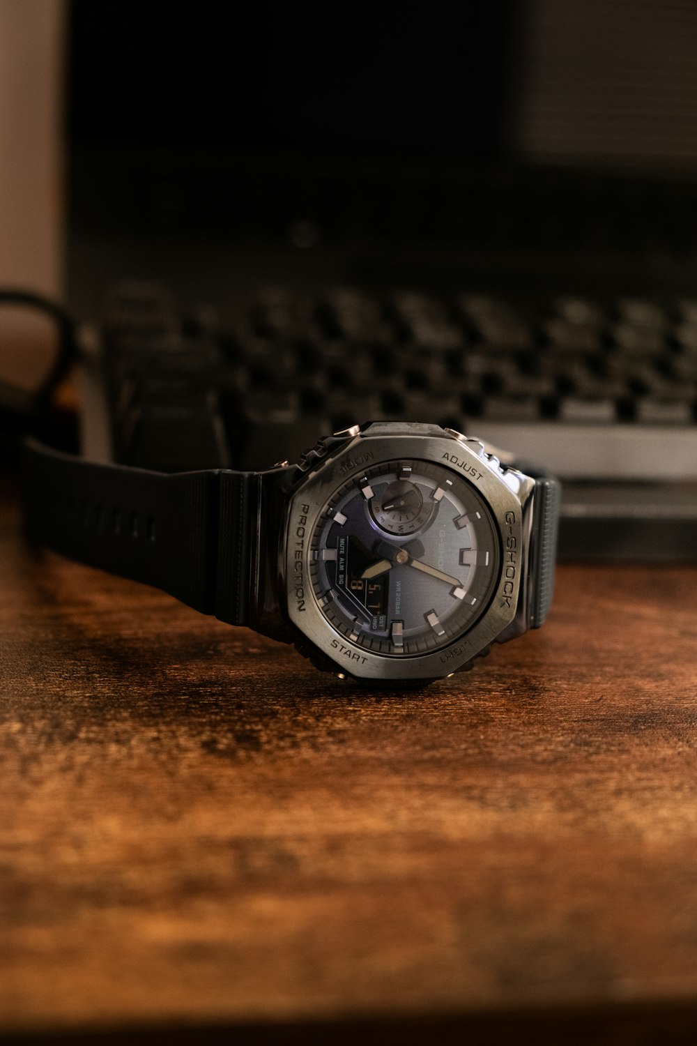 a silver watch on a wooden surface