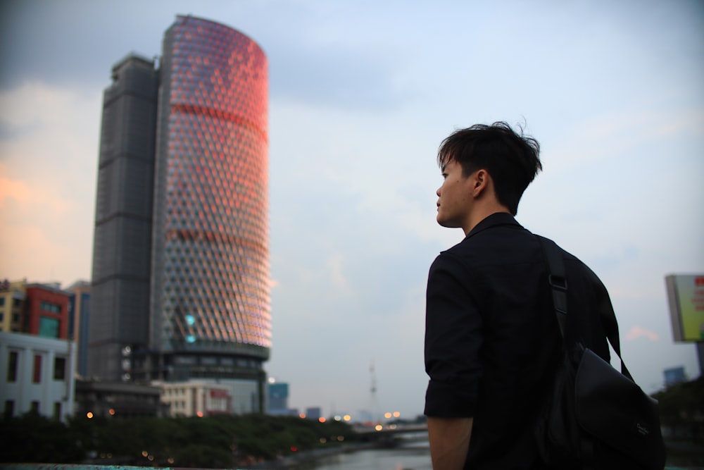 a man standing in front of a tall building