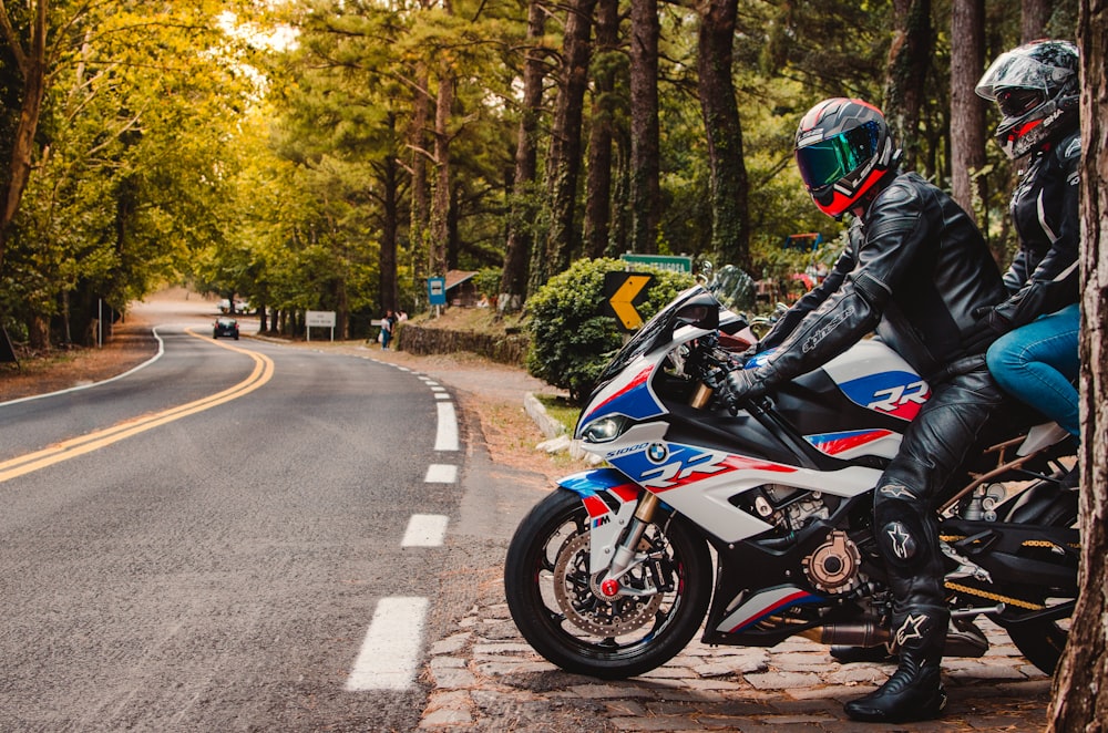 a couple of people ride on a motorcycle down a street