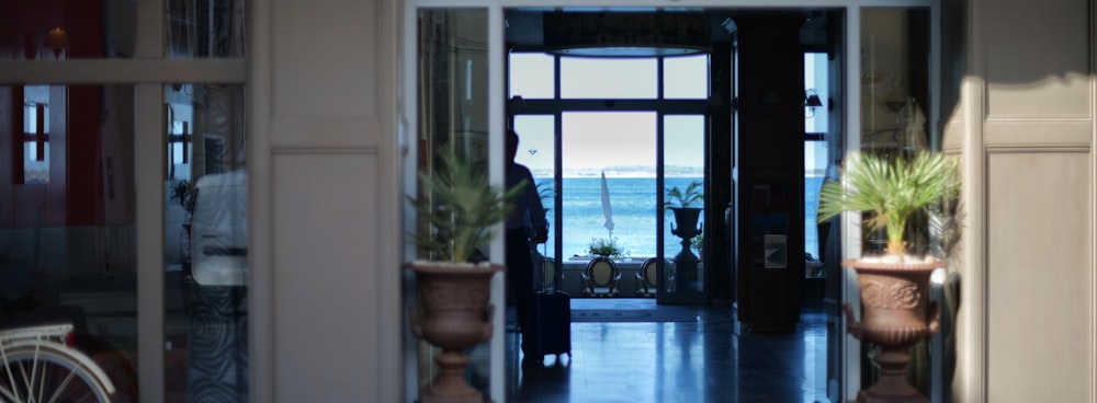 a room with a view of the ocean and a person standing in the doorway