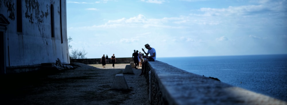 a group of people walking on a path by the water