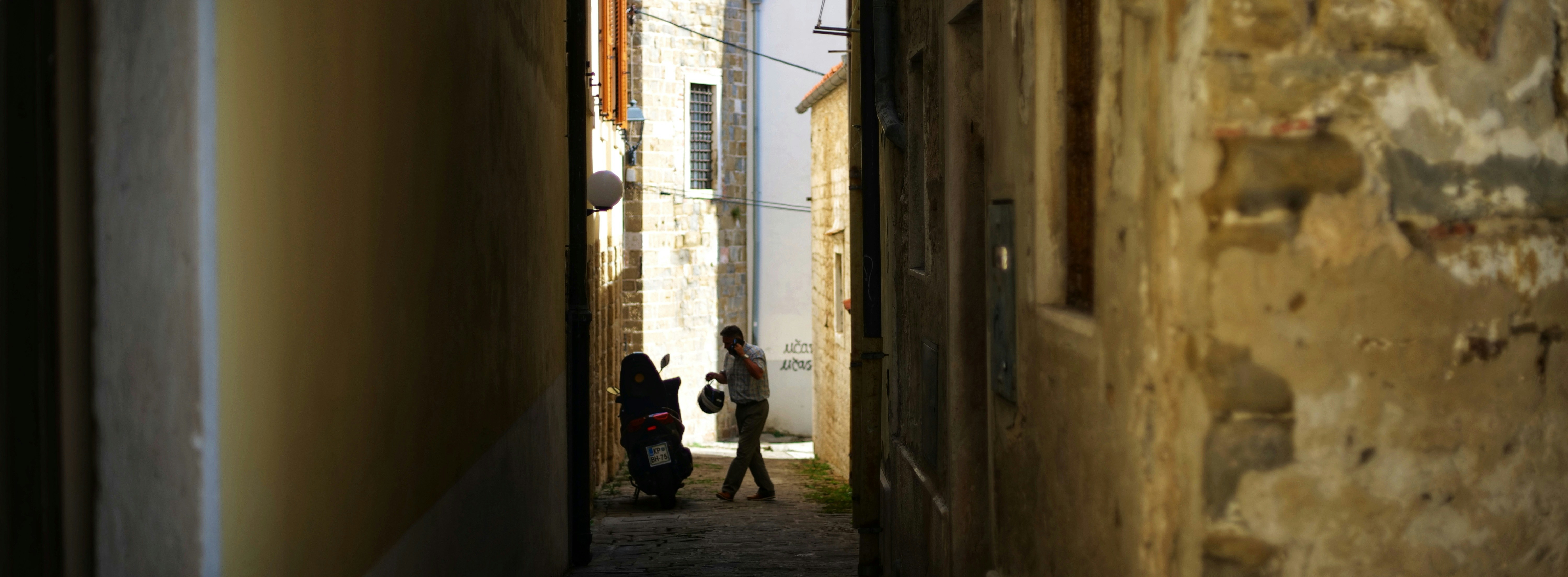 a person walking down a narrow alley