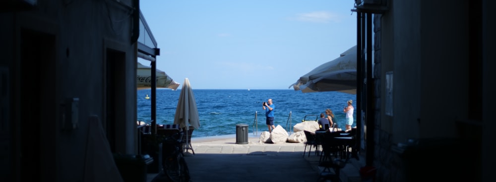 a group of people sitting at tables by the water