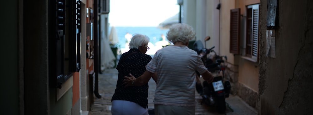 a couple of women walking down a sidewalk