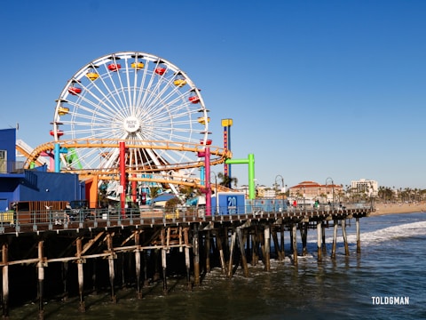 a ferris wheel on a pier with Santa Monica Pier in the background