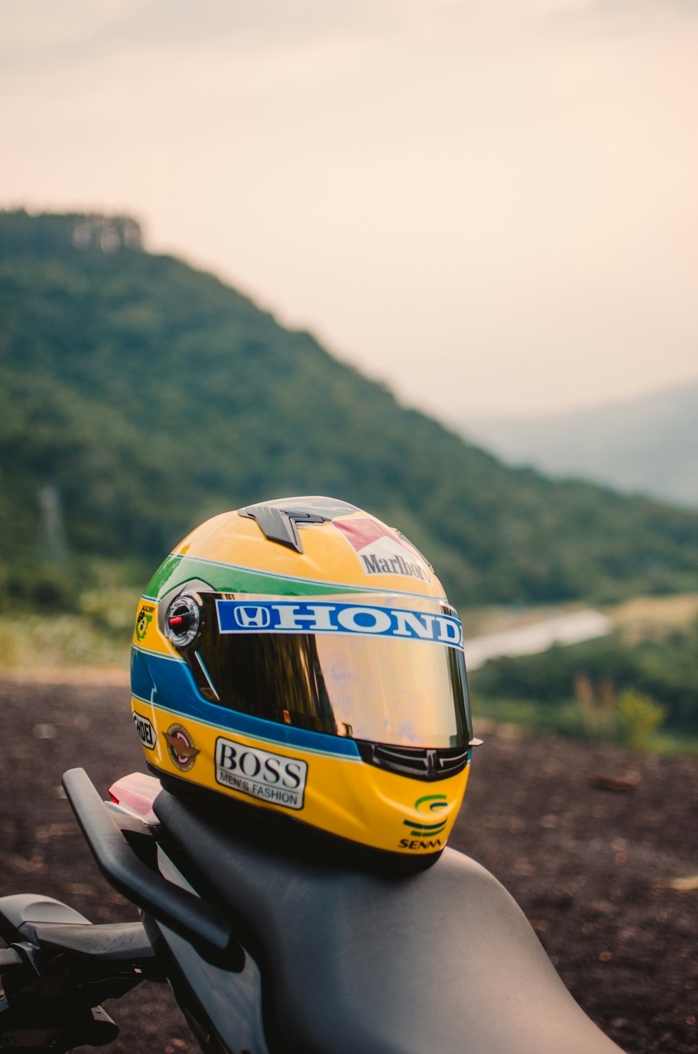 a yellow race car on a dirt road with a hill in the background