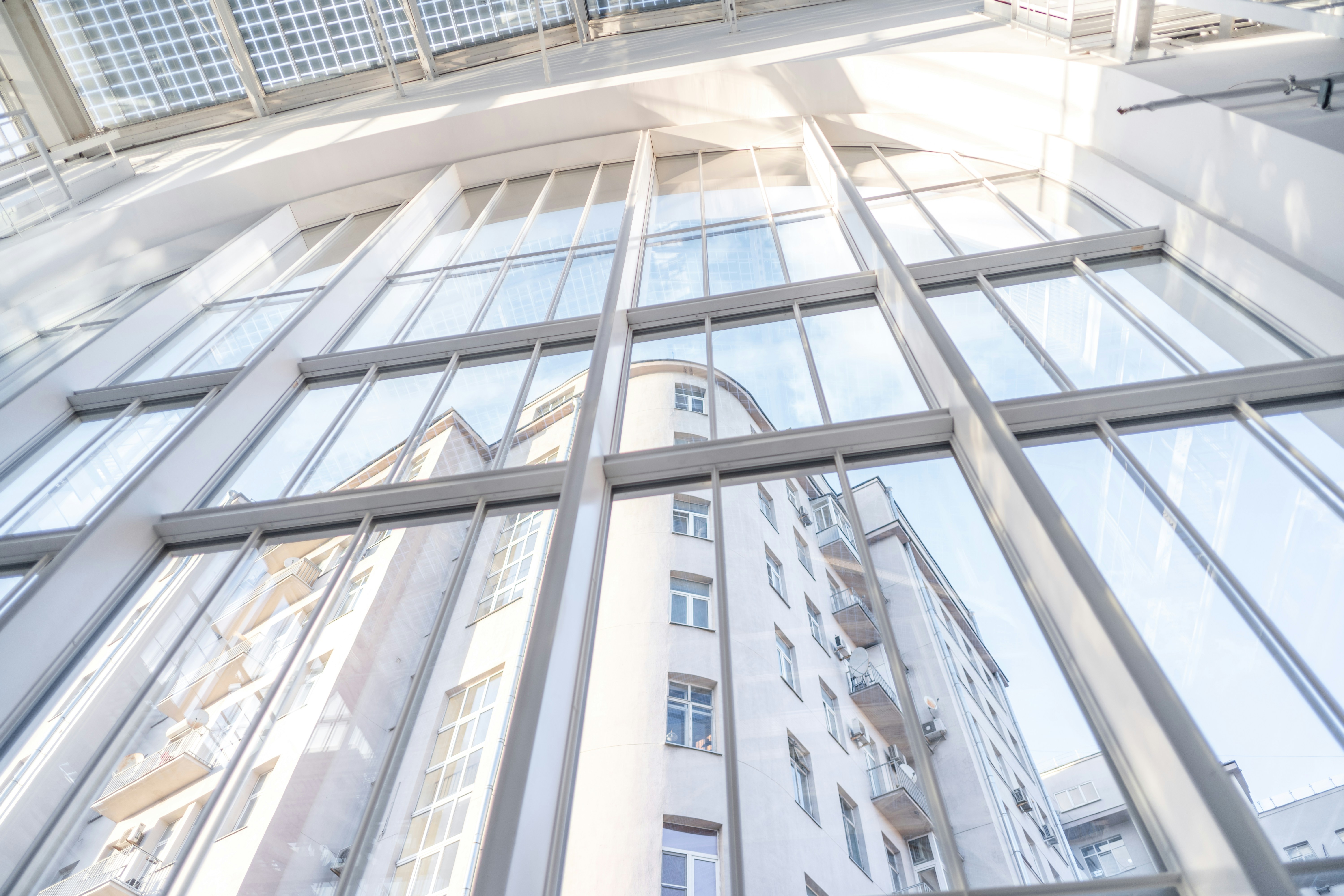 Modern glass building architecture exterior, clean lines, bright sky, professional