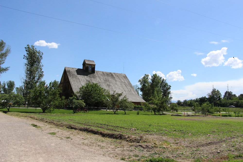 a house with a dirt road and trees around it