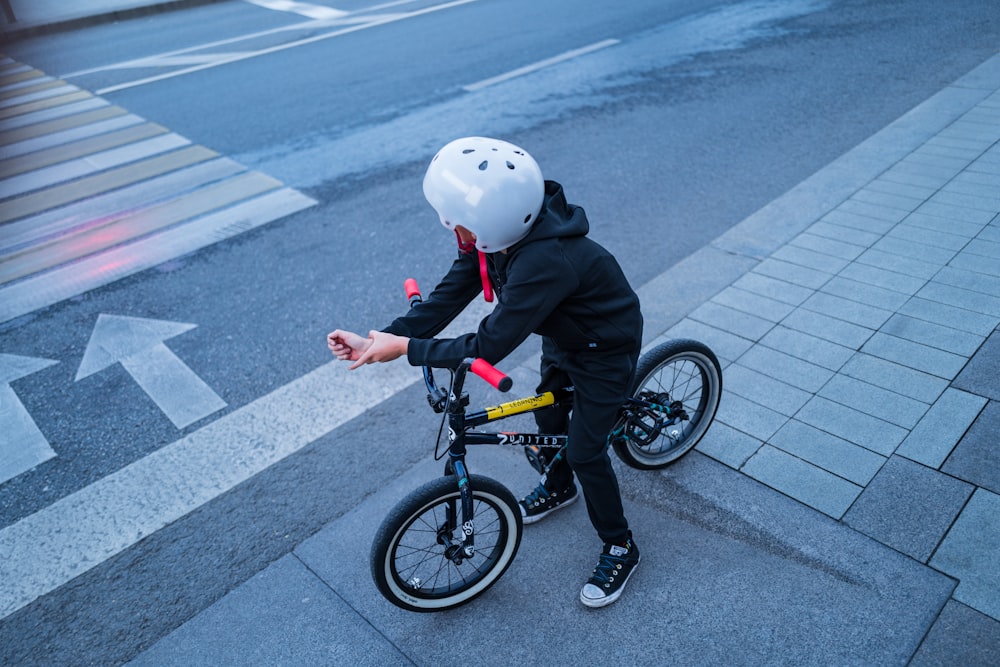 a person wearing a helmet riding a bicycle on a street