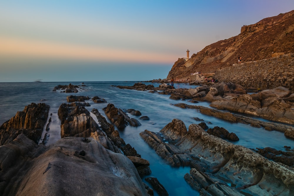 a rocky beach with a lighthouse