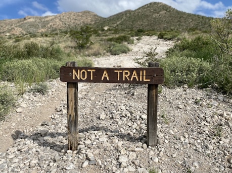 a sign in the middle of a rocky area