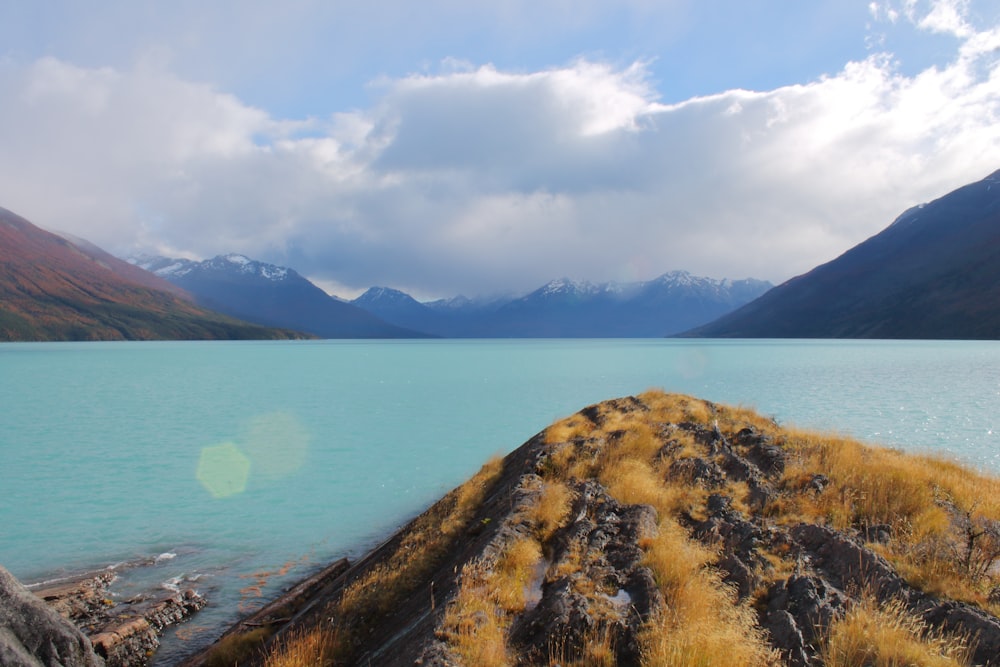 a body of water with mountains in the background