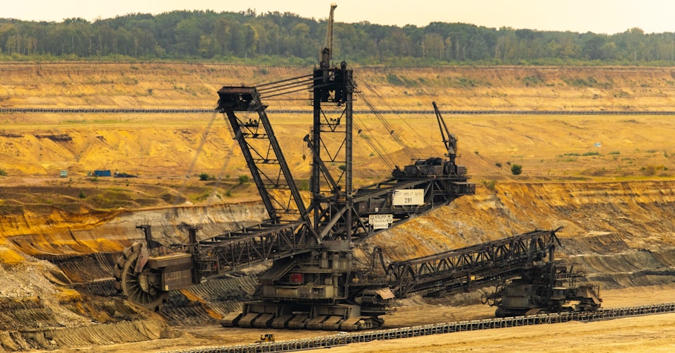 Large industrial machine working in an open field, illustrating the scale of resource extraction
