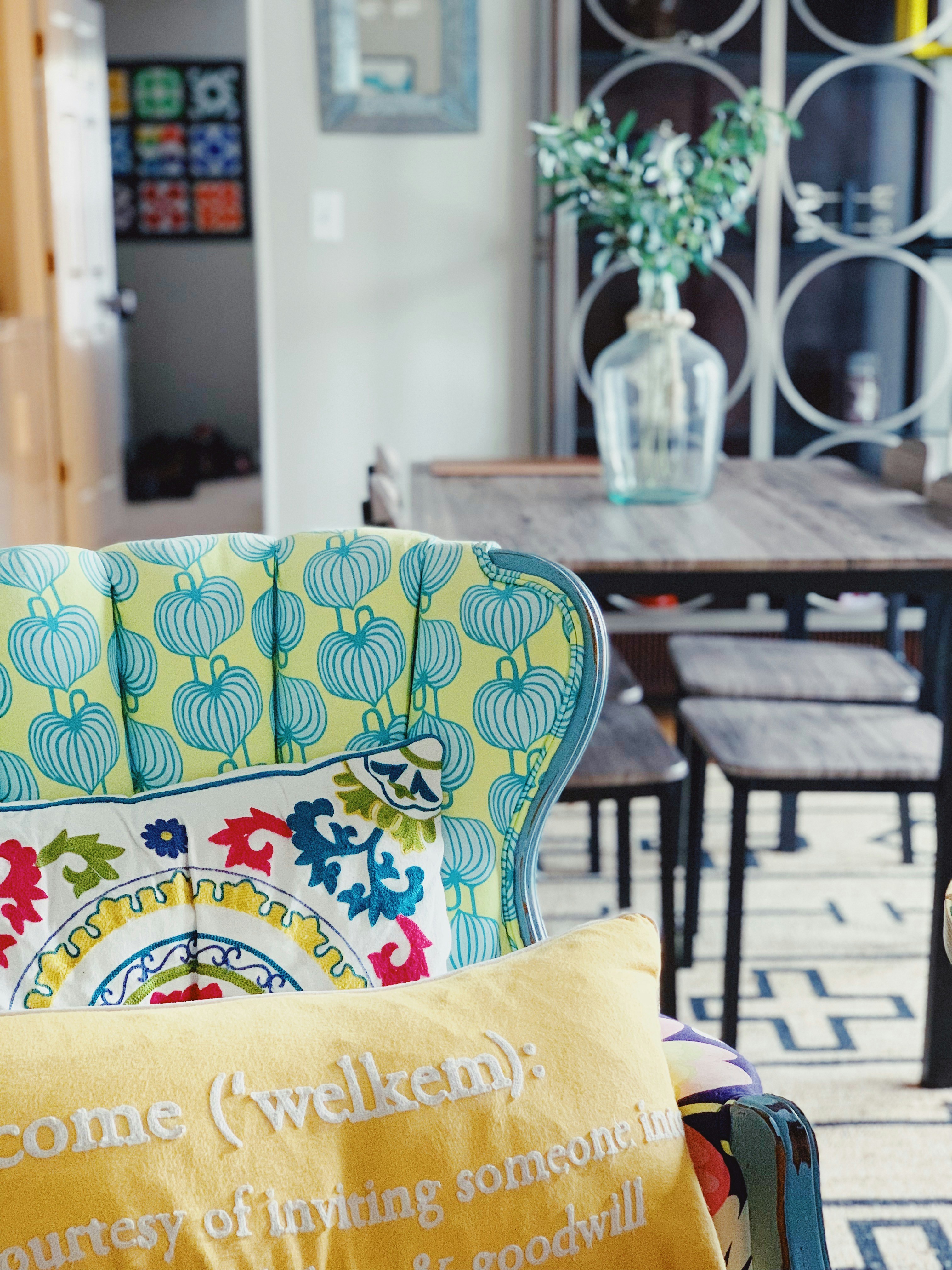 a table with chairs and a vase with flowers on it
