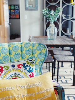 a table with chairs and a vase with flowers on it